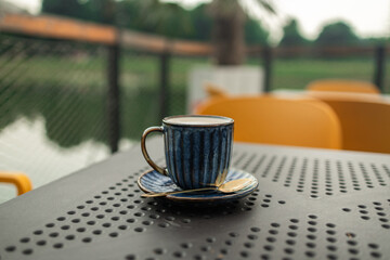 Hot coffee, milk, floral foam and aromatic coffee cups white cup is ready to serve customers in the morning, placed on a table in popular classic city coffee shop. High quality photo