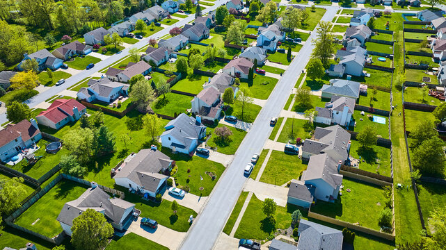 Pristine rows of houses in white collar suburban neighborhood aerial with landscaping and fences