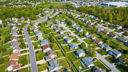Rows of pristine houses in suburban neighborhood aerial in summertime