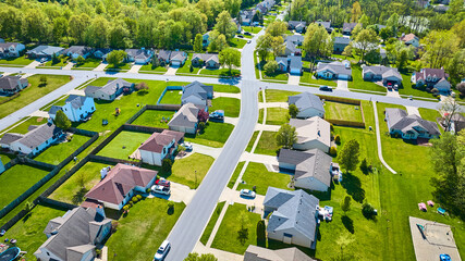 Houses in suburban neighborhood with wooden fences and clean roads aerial