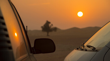 Naklejka na ściany i meble beautiful sunset in the desert with a silhouette of a car in the foreground.silhouette of a car in the desert against the backdrop of sunset