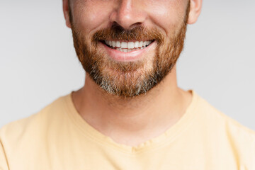 Closeup portrait of happy middle aged bearded man with toothy smile isolated on gray background. Dental procedure, orthodontist. Confident hipster with stylish beard cut after barbershop service