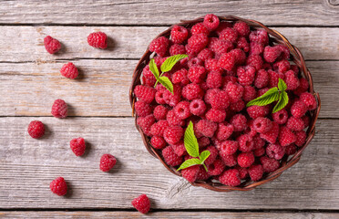 Raspberry in a basket .on wooden background © whitestorm