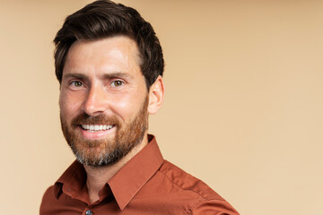 Obraz premium Portrait of handsome smiling middle aged man, handsome businessman looking at camera isolated on background, copy space. Happy bearded hipster after barbershop service