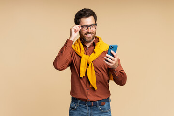 Handsome stylish smiling man holding smartphone using mobile app shopping online isolated on...
