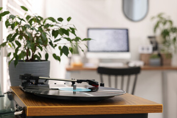Record player and houseplant near cozy workplace at home