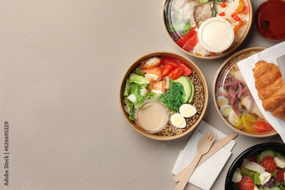 Sticker Tasty food in containers with wooden knife and fork on light grey table, flat lay. Space for text