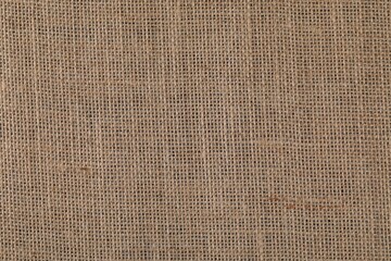 Brown burlap fabric as background, top view