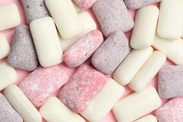 Different tasty colorful bubble gums on pink background, flat lay