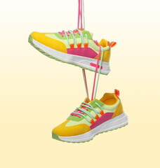 Pair of stylish sneakers in air on color gradient background