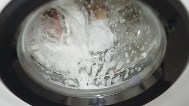 Modern Washing Machine in process of wahing a dirty clothes, slow motion