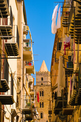 narrow street in cefalu with the church like background , italy 