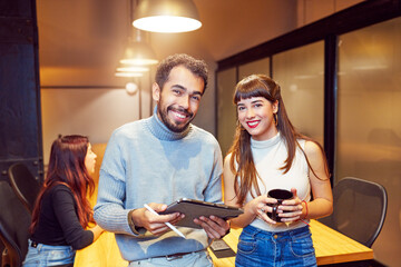 portrait two smiling young Latin American businessmen employee looking at camera in office interior