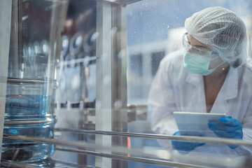 Female factory workers check machine systems at the industrial factory. Women working in clean rooms for beverage and food production