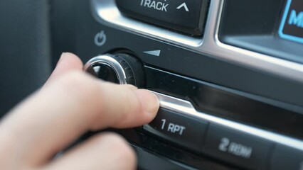Woman Turning On the Car's Radio, Driver Pressing to Button Of Car Tape to Listening Music or Radio Broadcast. Close Up Shot of Unrecognizable Person's Hand. 4K Prores.