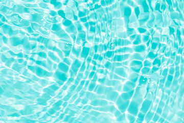 Blue water with ripples on the surface. Defocus blurred transparent blue colored clear calm water surface texture with splashes and bubbles. Water waves with shining pattern texture background.