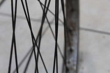 close up of a bicycle wheel with dirty and rusty spokes. suitable for transportation and bicycle theme.