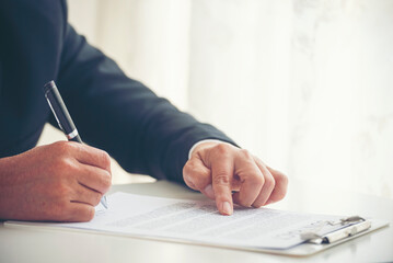 Businessman hand using pen signing on new contract to starting projects in conference room. Close...