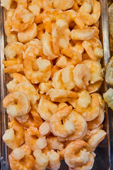 Cooked shrimp, frozen, dead, container at grocery store, meat department