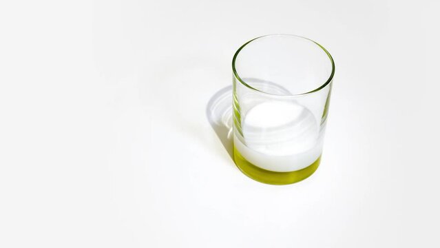 Milk fills glass beaker on white background