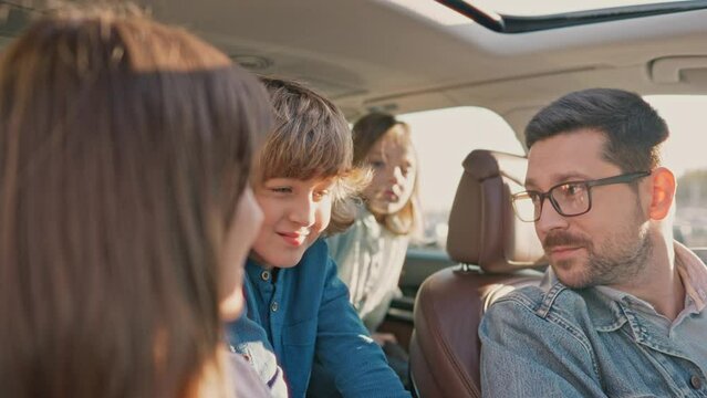 Family travel by car. Happy family having fun summer vacation with their children. Safety riding car concept wide angle inside car view image. Tourism. Road safety. Life insurance.