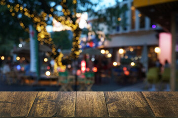 Empty dark wooden table in front of abstract blurred boken bankground of restaurant. Can used for display or montage your products. Mock up for space.