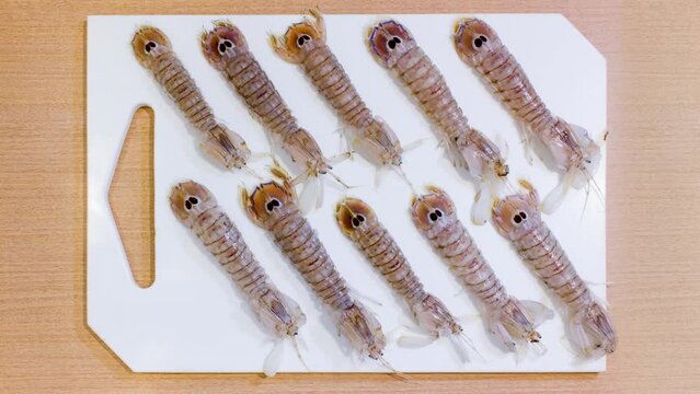 Raw mantis shrimps move on the kitchen cutting board