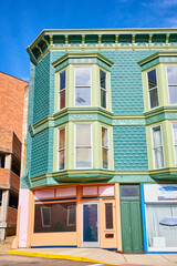 Partial view of brick building with teal paint and bay windows in Public Square in Mount Vernon