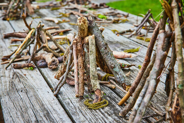 Picnic table wood covered in small stick teepee piles