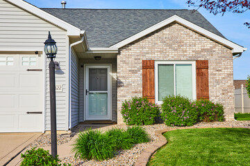 Light pole post, tan, gray bricks, slate gray checkered splotched roof white door rock river path