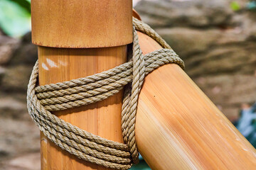 Gorgeously wrapped shiny bamboo poles with thick rope in zen setting