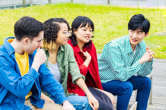 ベンチに座って話す多国籍学生グループ