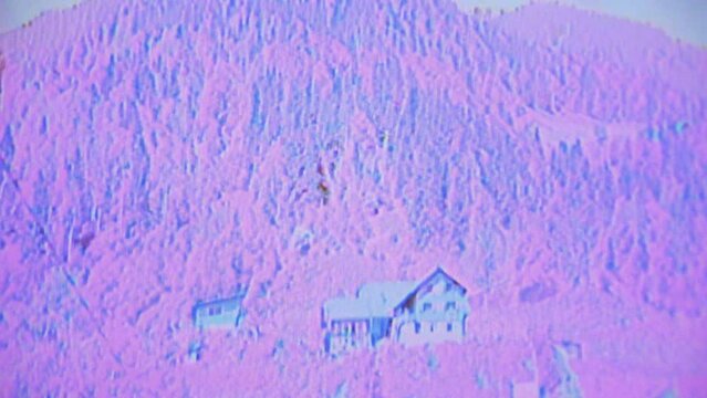 Old school VHS glitch of static circuit bending on haunted house on hillside of forest