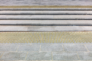 wide modern stone staircase with yellow nonskid tactile paving for a convenience of pedestrians
