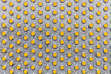 yellow tactile guide on grey granite sidewalk for visually impaired people