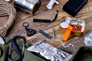 Wilderness survival kit on wooden table.