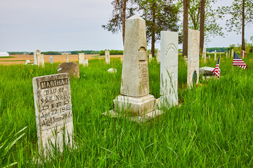 Four large headstones, old, graveyard, summer, memorial, small American flags by grave