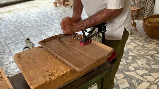 Grip the wooden plate to carve and polish the handmade manmade home-made wood artisan as carpenter contemporary art skill of woodworking workshop in middle east asia Gilan decoration craft furniture