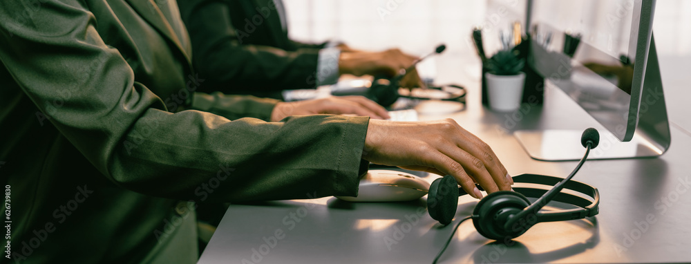 Aufkleber panorama focus hand holding headset on call center workspace desk with blur background of operator t