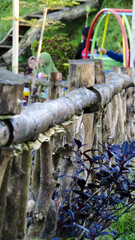 Rainbow chain swing in playground. Looked at from behind the fence 