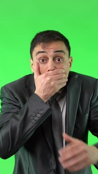 Talkative man in suit covering mouth with hand