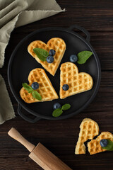 Dessert Belgian waffles in the shape of hearts with berries