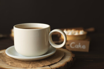 Still life with a cup of coffee with milk, flowers and cakes