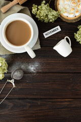 Still life with a cup of coffee with milk, flowers and cakes