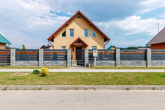 New small house against the blue sky with asphalt road and green grass