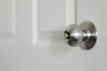 Stainless steel door knob or the handle on the wooden door In a brightly lit room. concept of cleanliness and hygiene. Selective focus. - obrazy, fototapety, plakaty