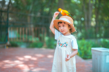 cute baby girl in dress and hat with activity feed food bird happy time