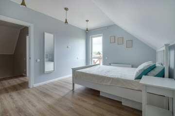 Modern bedroom in a new house in bright colors with a minimum amount of furniture