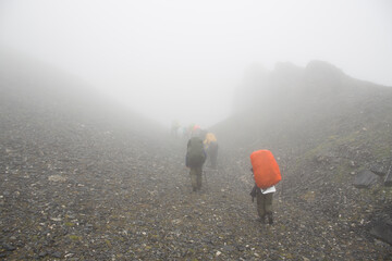 soft focus. Shooting in foggy weather. A group of tourists is walking in the mountains in the fog.