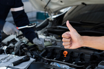 Hand of customer thumbs up for good service in auto repair shop.Customer review.Repair service.Car Machanic.Car repair and maintenanc concept.